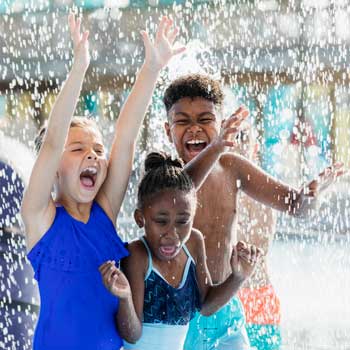 kid with ostomy playing in water